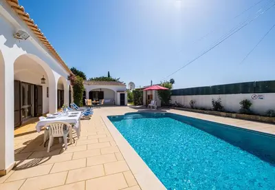 a swimming pool with tables and chairs next to a house at Villa Retiro no Campo in Guia