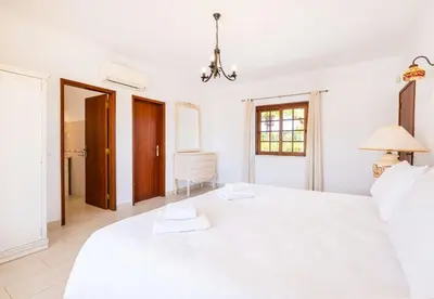 a white bedroom with a large white bed at Villa Retiro no Campo in Guia
