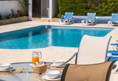 a table with food and drinks next to a swimming pool at Villa Retiro no Campo in Guia