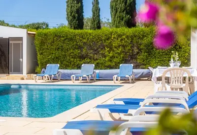 a pool with chaise lounge chairs and a table and chairsktop at Villa Retiro no Campo in Guia