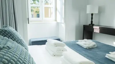 a large kitchen with white cabinets and a window at Faro Old Town Apartments in Faro