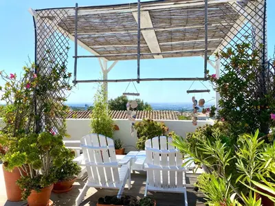 a patio with white chairs and potted plants at Holiday Home Vila Verão Nur für Erwachsene by Interhome in Santa Bárbara de Nexe