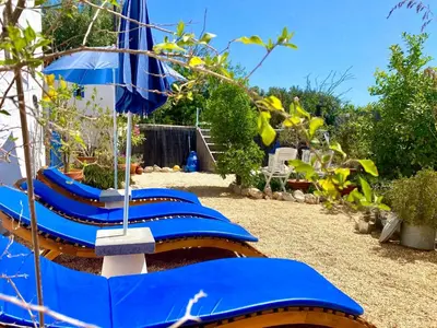 a row of blue lounge chairs with an umbrella at Holiday Home Vila Verão Nur für Erwachsene by Interhome in Santa Bárbara de Nexe