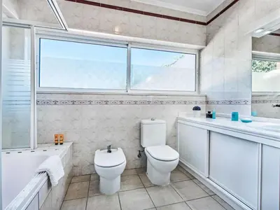 a bathroom with a toilet and a sink and a window at Holiday Home Chalet Villa Oceano mit privatem Pool by Interhome in Albufeira