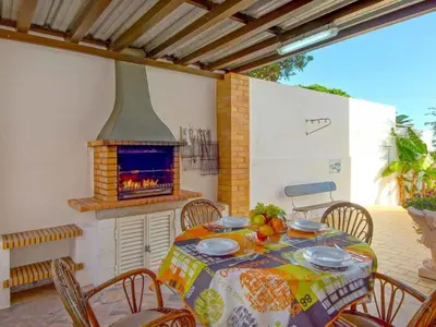 a table and chairs with a fireplace on a patio at Holiday Home Chalet Villa Albuar mit eigenem Pool by Interhome in Albufeira