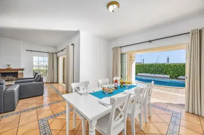 a dining room with a table and chairs and a couch at Villa Ventura by Villa Plus in Albufeira