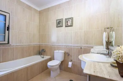a bathroom with a toilet and a tub and a sink at Villa Anthony by Villa Plus in Terras Novas