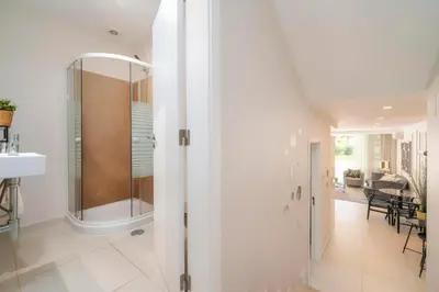 a bathroom with a walk in shower next to a dining room at Casa do Gil, Vale do Lobo Beach and Golf in Loulé