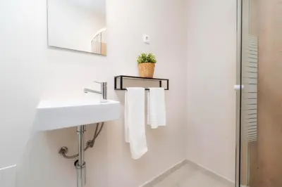a white bathroom with a sink and a mirror at Casa do Gil, Vale do Lobo Beach and Golf in Loulé