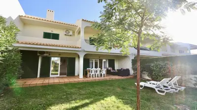 a house with a patio and chairs in the yard at Melias apartment - Cleverdetails, Vilamoura in Vilamoura
