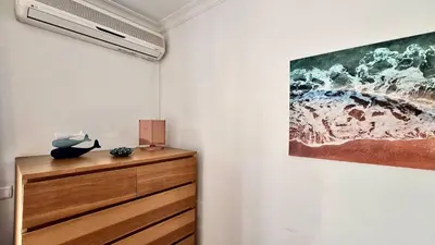 a room with a painting on the wall and a wooden dresser at Melias apartment - Cleverdetails, Vilamoura in Vilamoura