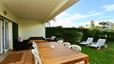 a patio with a wooden table and white chairs at Melias apartment - Cleverdetails, Vilamoura in Vilamoura