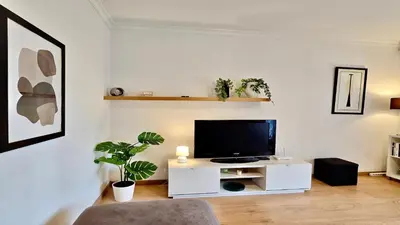 a living room with a tv on a white cabinet at Melias apartment - Cleverdetails, Vilamoura in Vilamoura