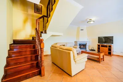a living room with a staircase and a couch at Villa Carela in Albufeira