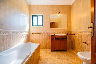 a bathroom with a tub and a sink at Villa Carela in Albufeira