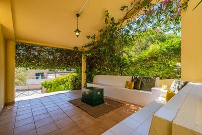 a patio with a white bench and plants at Villa Carela in Albufeira