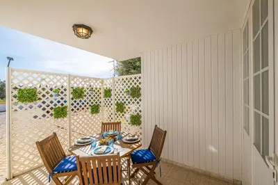 a patio with a table and chairs and a fence at Margarida Apartment - Ping pong table in Albufeira