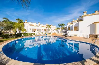 a large swimming pool in front of a villa at Margarida Apartment - Ping pong table in Albufeira