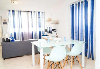a living room with a white table and white chairs at Margarida Apartment - Ping pong table in Albufeira