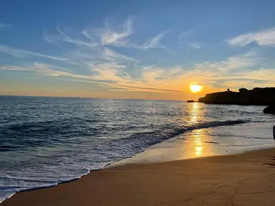 a sandy beach with rocks in the water at Casa Jokpa Mar Near So Rafael Beach in Albufeira