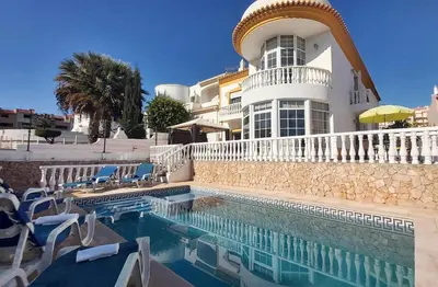a hotel with a swimming pool with chairs and a building at Vila Girassol by Stay ici Algarve Holiday Rental in Albufeira