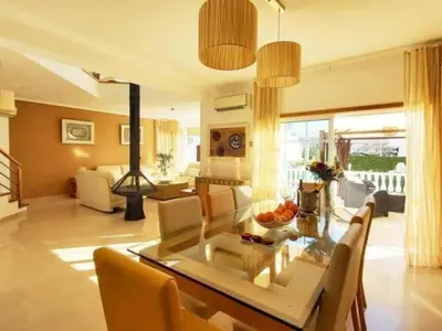 a living room with a glass table and chairs at Vila Girassol by Stay ici Algarve Holiday Rental in Albufeira