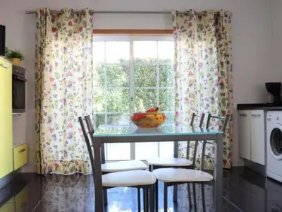 a kitchen with a table with chairs and a window at Vila Girassol by Stay ici Algarve Holiday Rental in Albufeira