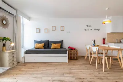 a bedroom with a bed and a table and a kitchen at Rocco del Mar by Portucasa in Albufeira