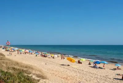 a group of people on a beach with umbrellas at Blife Delya private rooms at Faro beach in Faro