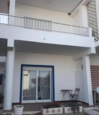 a white house with a balcony and a patio at Blife Delya private rooms at Faro beach in Faro