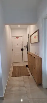 a hallway with a white door and a wooden cabinet at Casa Cardoso in Quarteira