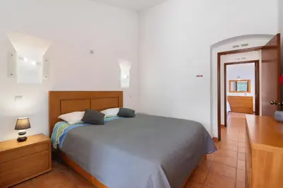 a dining room with a table and chairs and a stone wall at Lotus Villa, Albufeira in Albufeira