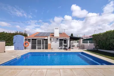 a red umbrella sitting next to a swimming pool at Lotus Villa, Albufeira in Albufeira