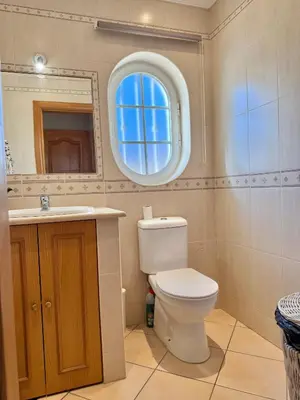 a bathroom with a toilet and a sink and a mirror at Villa Sun & Shine in Faro