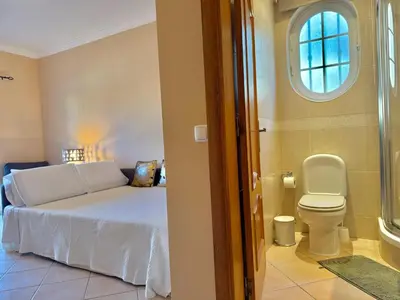 a bedroom with a bed and a toilet and a window at Villa Sun & Shine in Faro