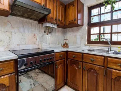 a kitchen with wooden cabinets and a sink and a stove at Algarve Sun by Stay ici - Algarve Holiday Rental in Albufeira