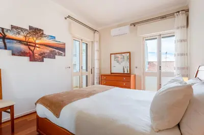 a white bedroom with a bed and a window at Cosy 2Bdr Flat in Faro Downtown by LovelyStay in Faro