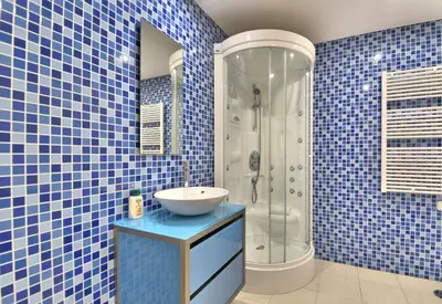 a blue tiled bathroom with a sink and a shower at Vilamoura Aquamar in Quarteira
