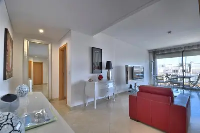 a living room with a red couch and a table at Vilamoura Aquamar in Quarteira