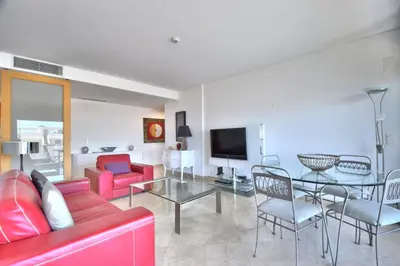 a living room with a red couch and a table at Vilamoura Aquamar in Quarteira