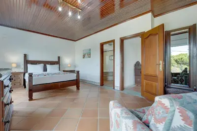 a bedroom with a bed and a dresser and a television at Villa das Buganvilias by Delilah Collection in Albufeira