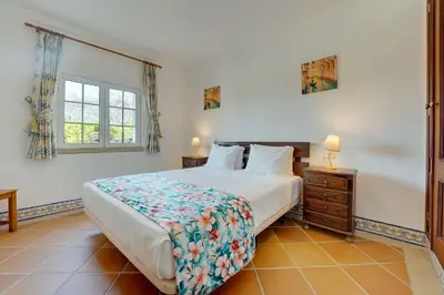 a bedroom with a bed and a wooden ceiling at Villa das Buganvilias by Delilah Collection in Albufeira