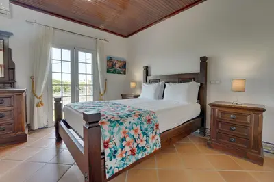 a bedroom with a bed and a couch at Villa das Buganvilias by Delilah Collection in Albufeira
