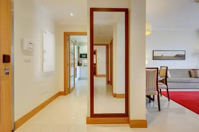 a dining room with a table and a sailboat on the wall at The Prestige @ The Vilamoura Residences in Quarteira