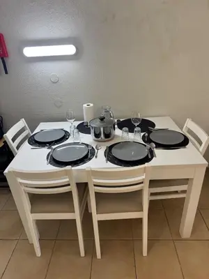 a white table with four chairs and plates on it at Relaxing studio in Albufeira Jardim in Albufeira