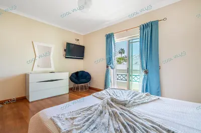 a bedroom with a bed and a tv and a window at Villa Cibel - Beach & Golf 10pax in Guia