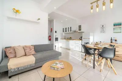 a living room and kitchen with a couch and a table at Sunlit Balcony & Open Space Flat by HostWise in Albufeira