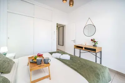 a white bedroom with a bed and a table at Sunlit Balcony & Open Space Flat by HostWise in Albufeira