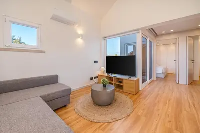 a living room with a couch and a flat screen tv at Marina Búzios Vilamoura Central 2-Bedroom Apartments in Vilamoura