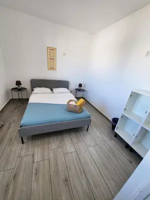 a bedroom with a bed and a wooden floor at Blife Troya private rooms at Faro beach in Faro